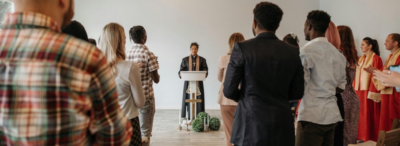 A clean and modern church setting with a traditional church leader with attendants from different backgrounds, representing intercultural leadership.