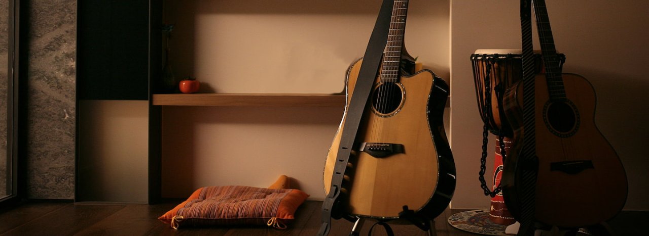 A room with a guitar and djembe drum next to a cushion, representing multicultural worship and the course at All Nations college.