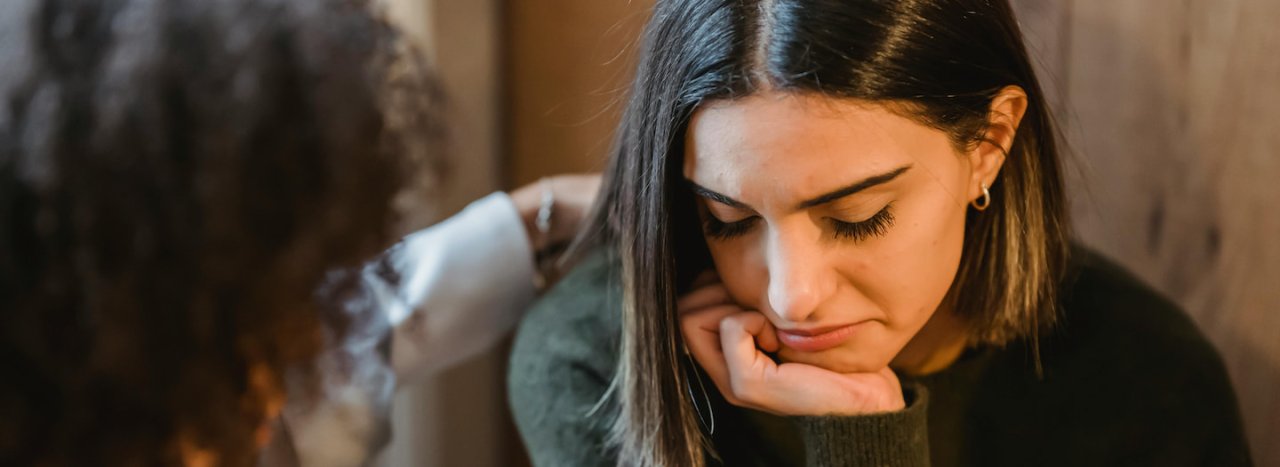 A young student discourage or distressed being comforted and encouraged by an older person, representing pastoral care at All Nations.
